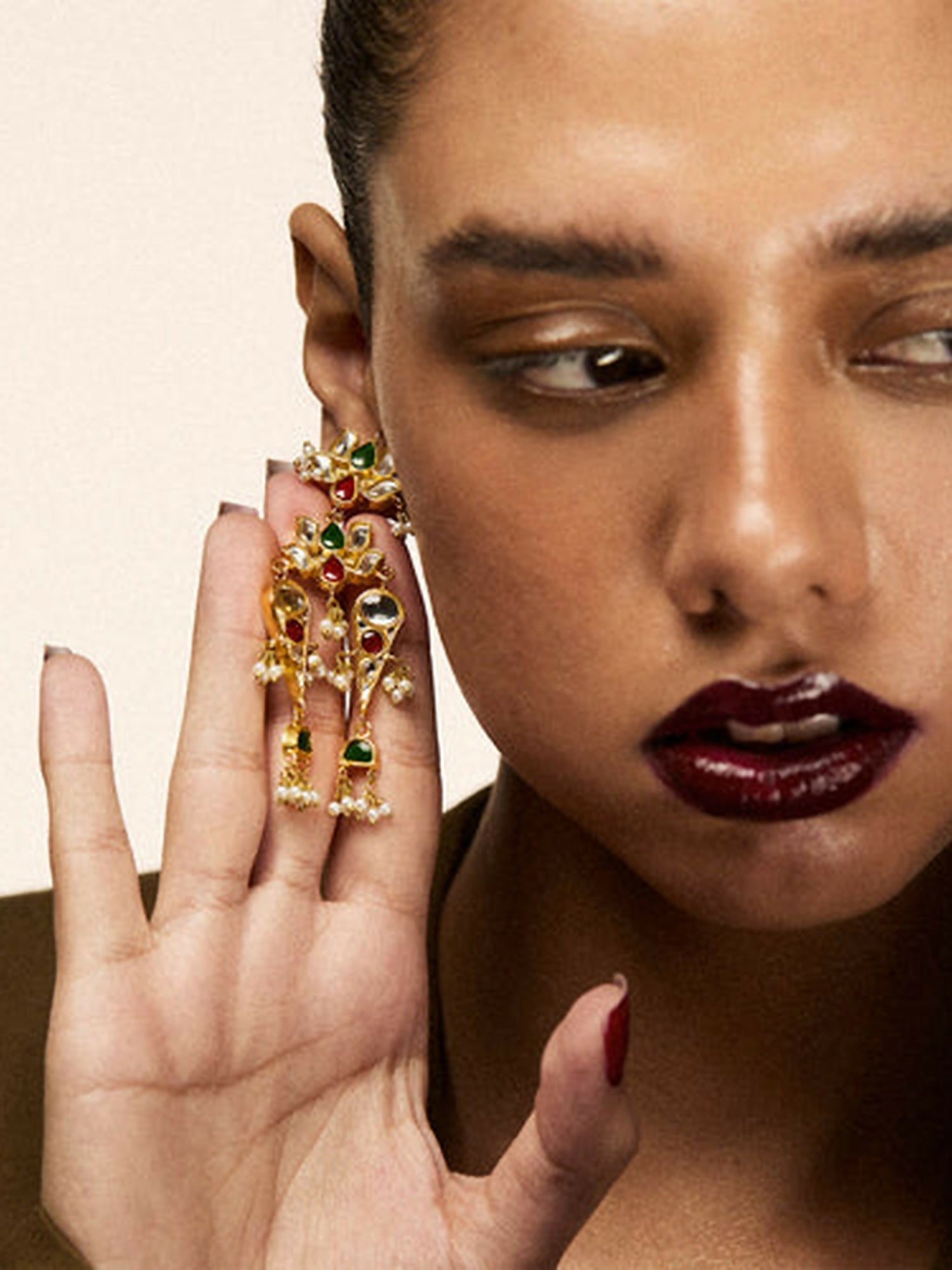 Jugnu by Hussain Rehar Lotus Cascade gold-tone earrings with floral motifs, green and red gemstone accents, cascading chains, and bead details, festive elegant accessory.
