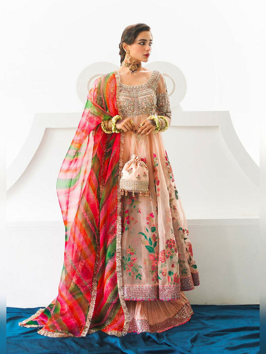 Stitched 3-piece suit by Hussain Rehar with rose gold organza peshwaz featuring embellishments and printed panels, paired with crushed silk sharara and multicolored striped organza dupatta with kiran.