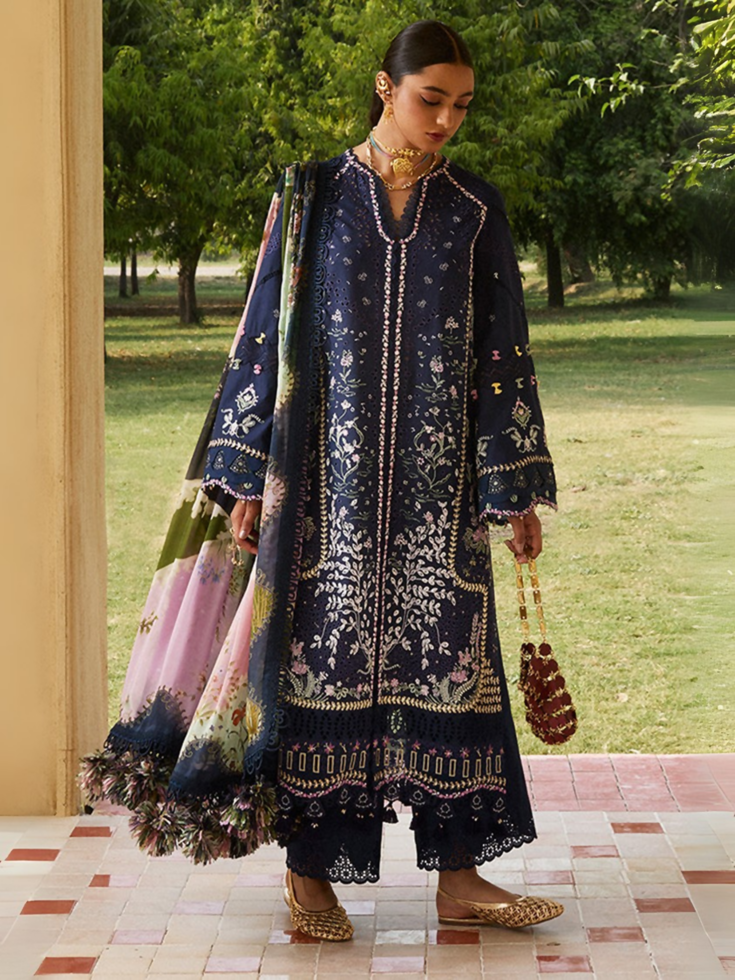 Deep blue embroidered lawn ensemble by Sana Yasir with organza details, digital printed dupatta, and cambric trouser.