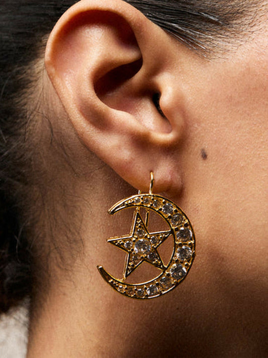 Jugnu by Hussain Rehar Celestial Crescent gold earrings with crescent-shaped design, white starburst stone accents, whimsical elegant accessory.