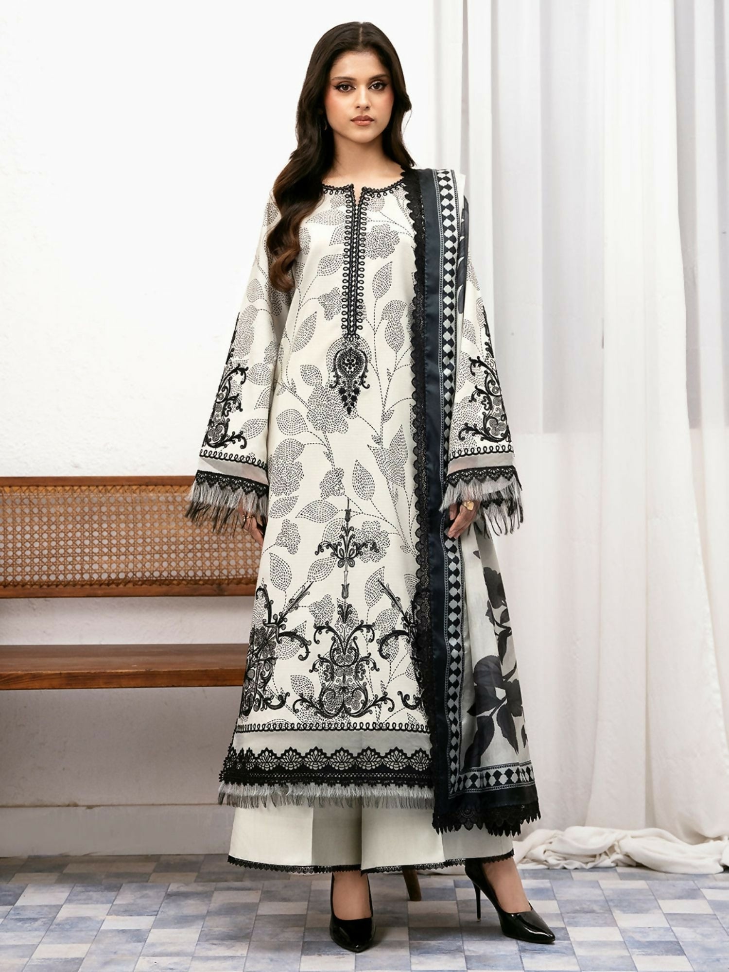 Unstitched 3-piece black and white suit displayed flat, featuring a digital printed shirt with embroidered motifs, printed dupatta, and matching trouser fabric.