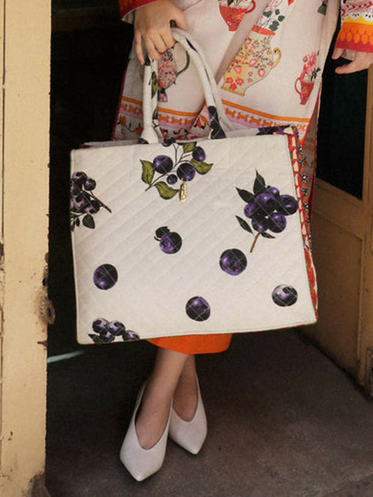 Bramble Quilted ivory tote bag with playful blueberry print, spacious interior, and sturdy handles, chic everyday accessory for work, school, or casual wear.
