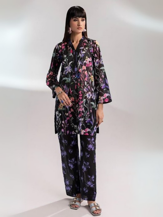 Woman wearing a black unstitched 2-piece lawn suit featuring multicolor floral print on the shirt and trousers, styled with long sleeves and a straight silhouette.