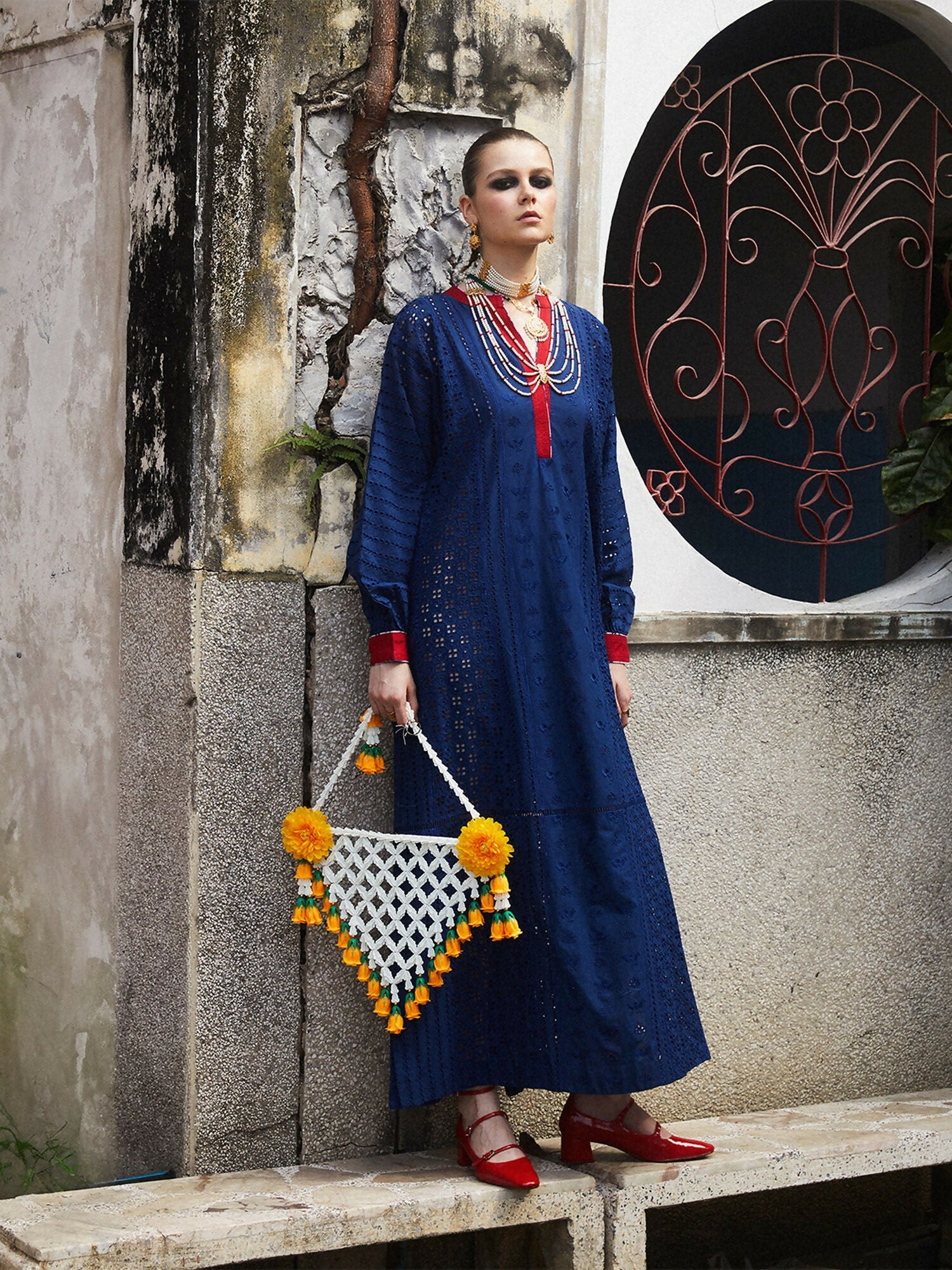 Woman wearing cotton long straight shirt with shiffli embroidery, slide slits, and red detailing on sleeves and neckline, 1-piece unstitched shirt.