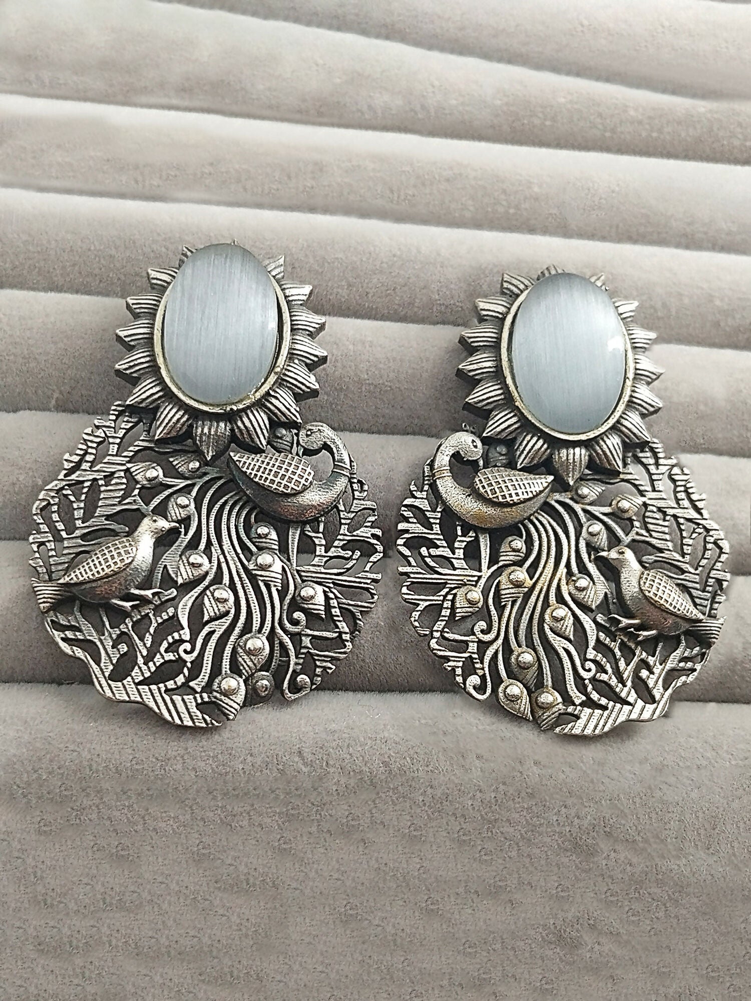 H&A Jewellery silver peacock motif earrings with white stone and sunburst design