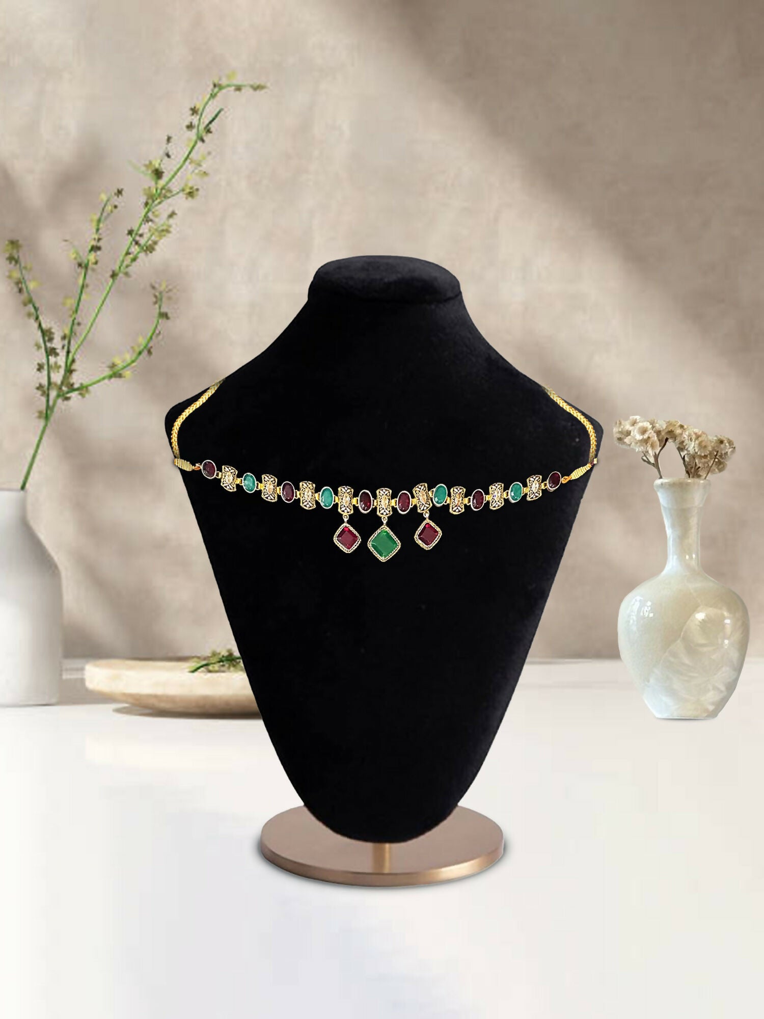 Glitter Jewellery gold-toned choker necklace with multicolor stones and dangling accents displayed on a black mannequin.