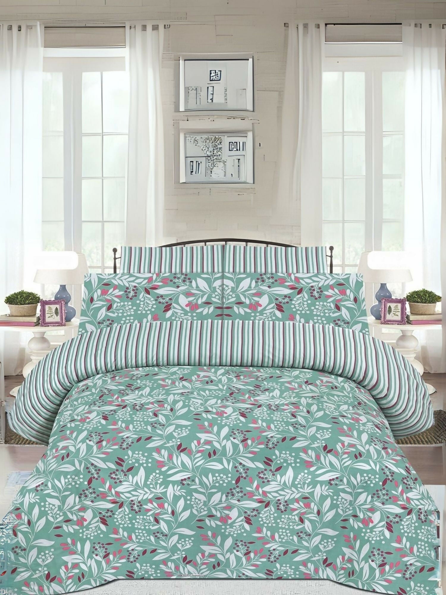 A mint green king size bedsheet with leafy print, laid out on a bed with matching pillow covers.