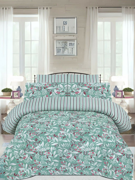A mint green king size bedsheet with leafy print, laid out on a bed with matching pillow covers.