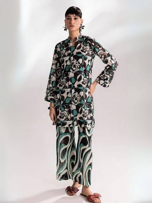 Woman wearing an unstitched 2-piece lawn suit from Parizad Vol-15, featuring a black, white, and teal geometric rose-printed shirt with full sleeves, paired with abstract swirl-printed wide-leg trousers.