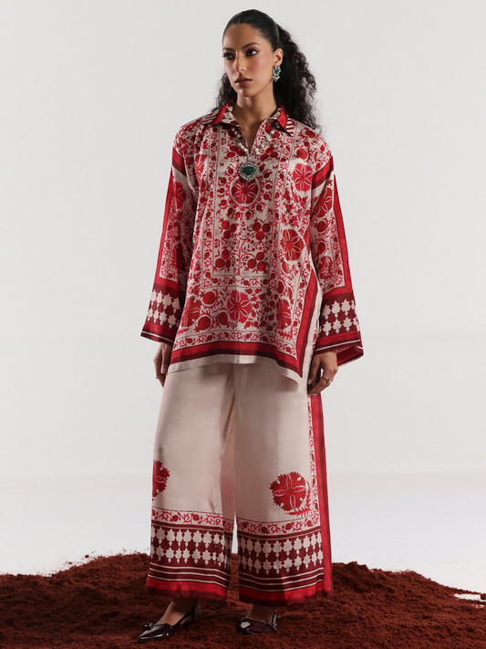 Model wearing a red and off-white digital printed silk co-ord set featuring bold floral motifs and geometric border detailing on a relaxed silhouette.
