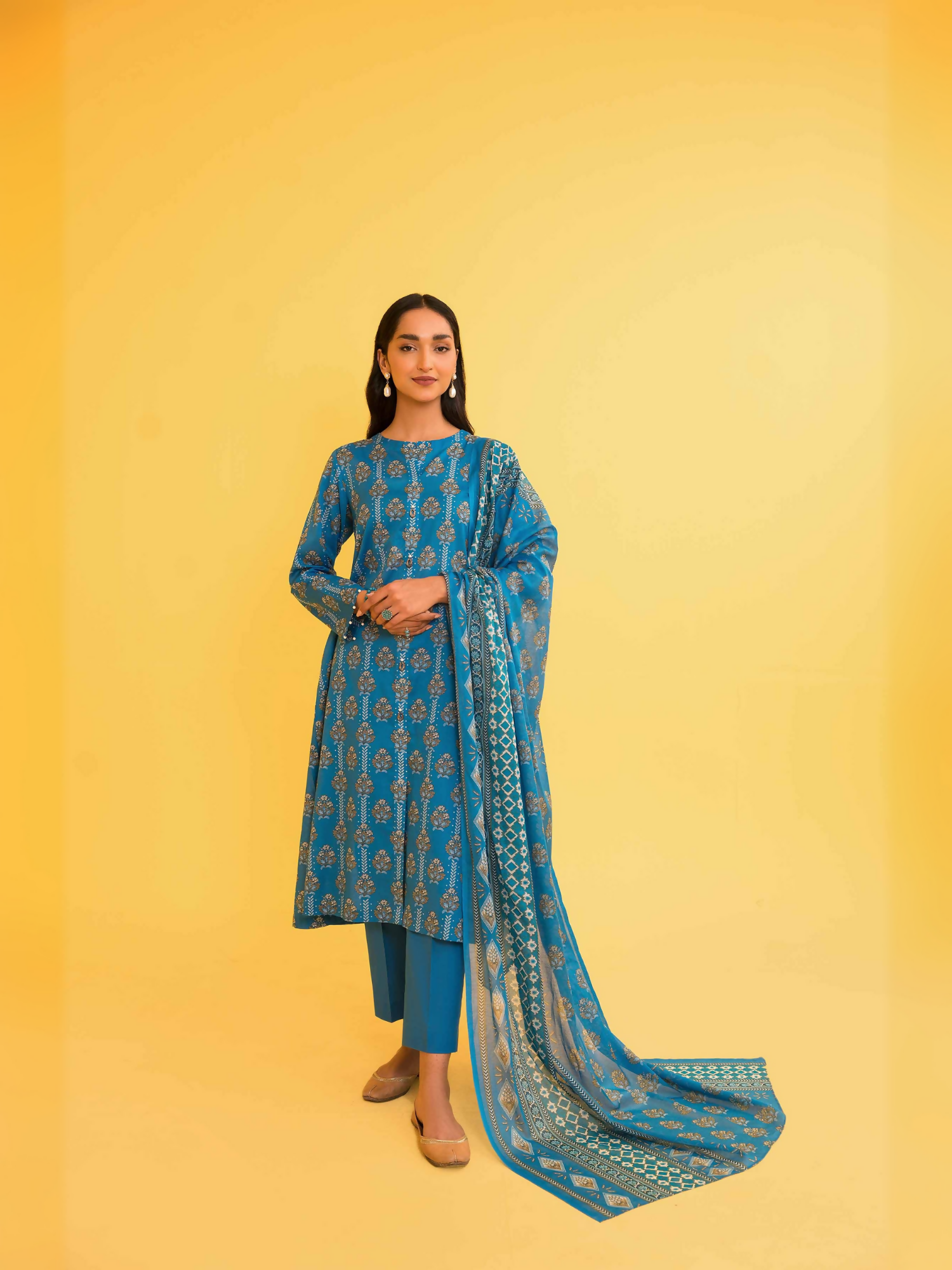 Nishat unstitched 3-piece lawn suit in blue with abstract embellished motifs, voile dupatta, and cambric trouser.