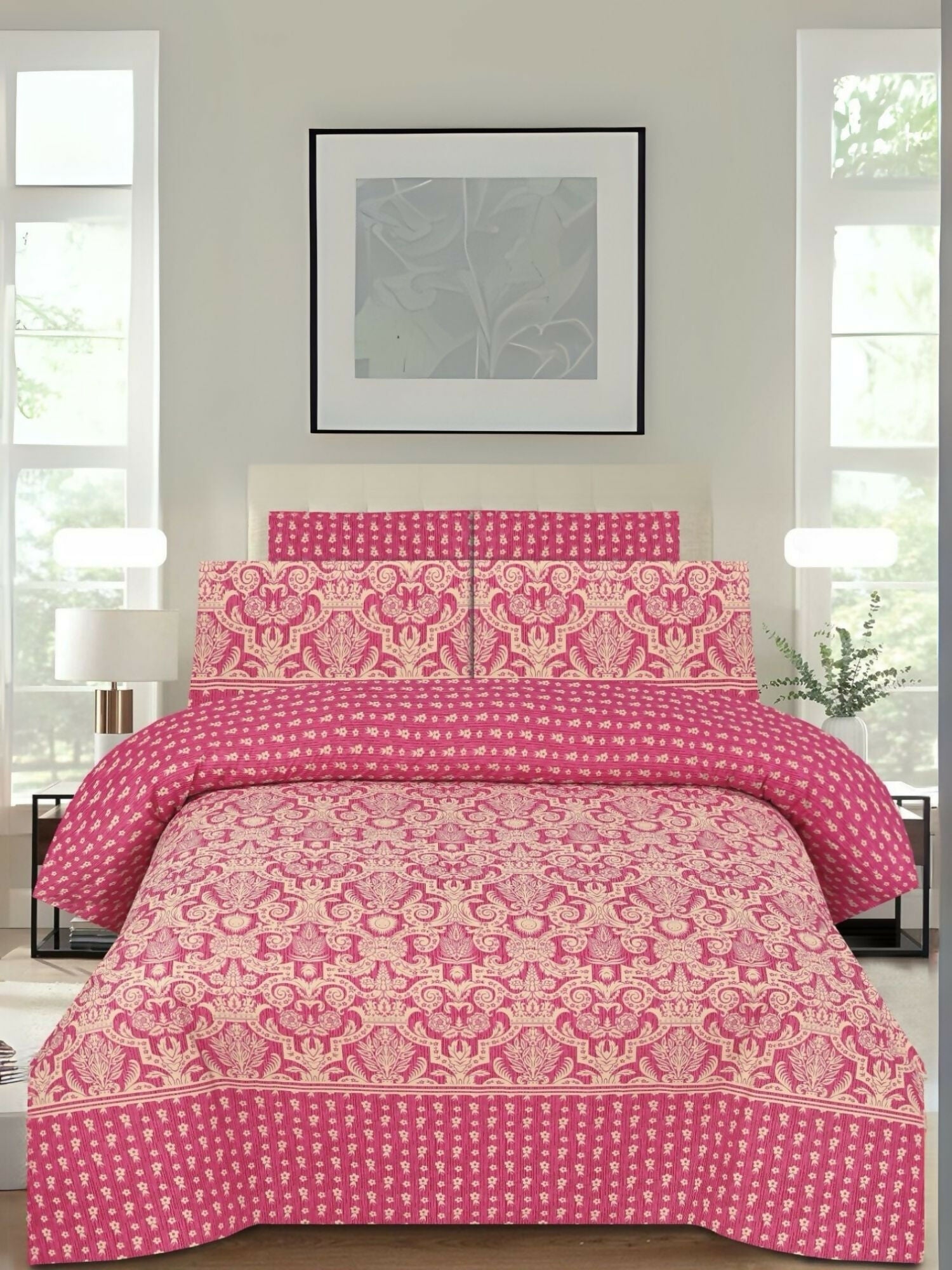 A pink bedsheet with golden printed design and matching pillow covers, spread neatly on a bed.