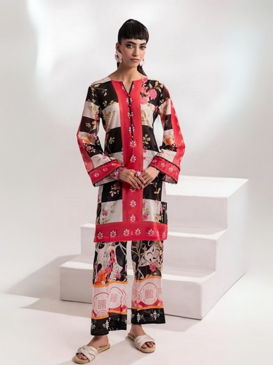 Woman dressed in a striking black unstitched 2-piece suit with vibrant multicolor floral prints on the shirt, styled with a coordinated printed trouser for a bold, contemporary look.
