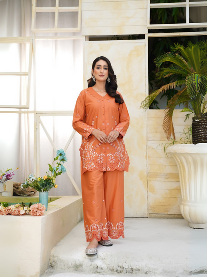 Girl wearing Trends Forever burnt orange lawn cotton embroidered kurta with white floral motifs, mirror work, and matching shalwar; stitched 2-piece suit