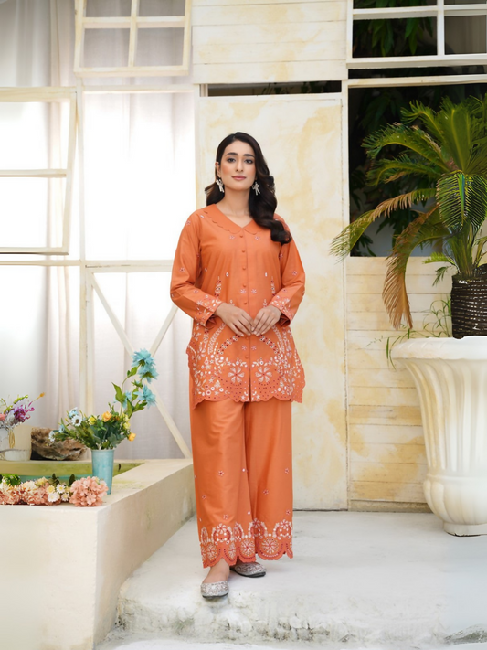 Girl wearing Trends Forever burnt orange lawn cotton embroidered kurta with white floral motifs, mirror work, and matching shalwar; stitched 2-piece suit