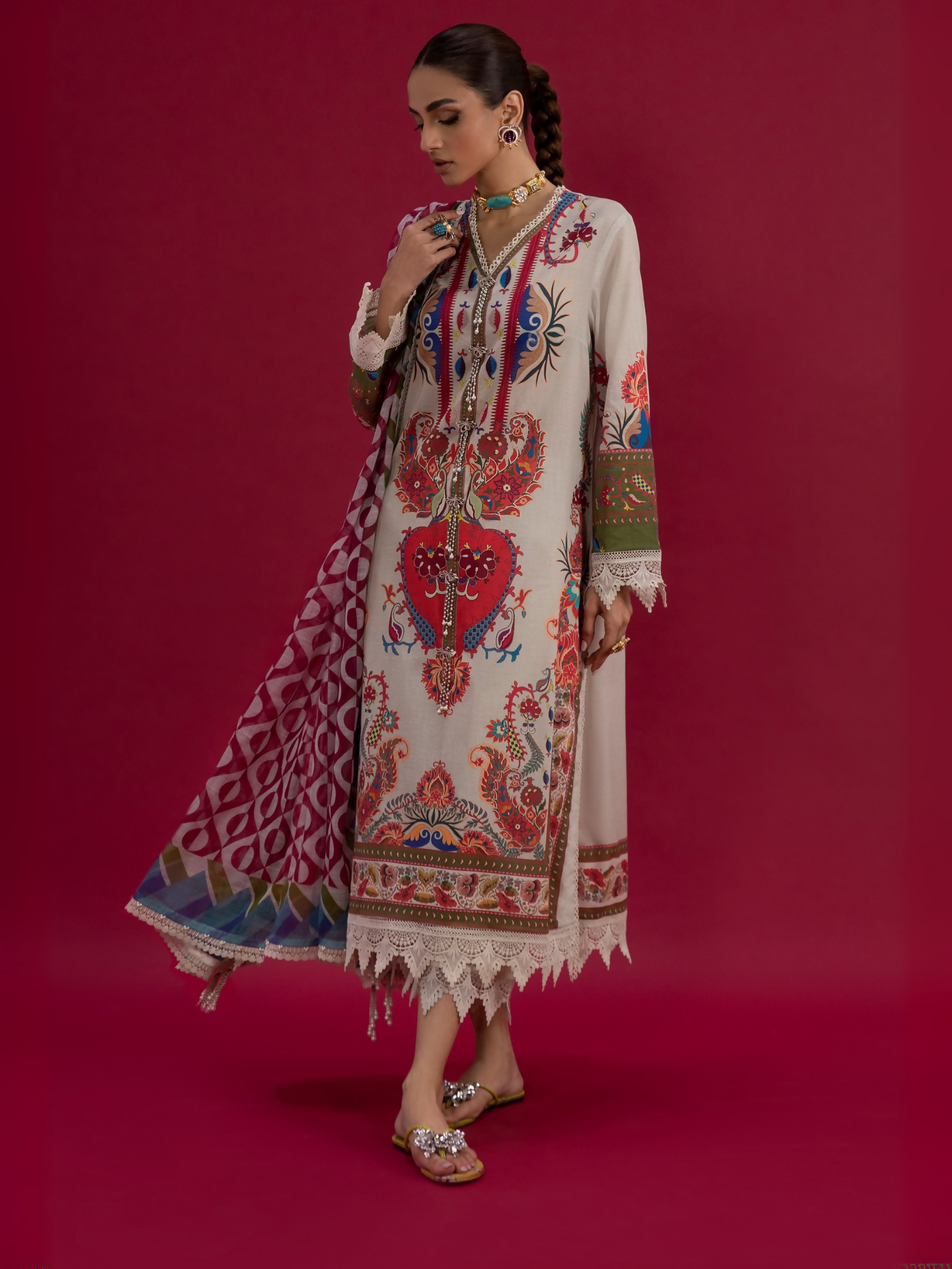 Woman wearing a nude unstitched 3-piece suit with multicolor printed design, paired with a matching printed dupatta and dyed cambric trouser.