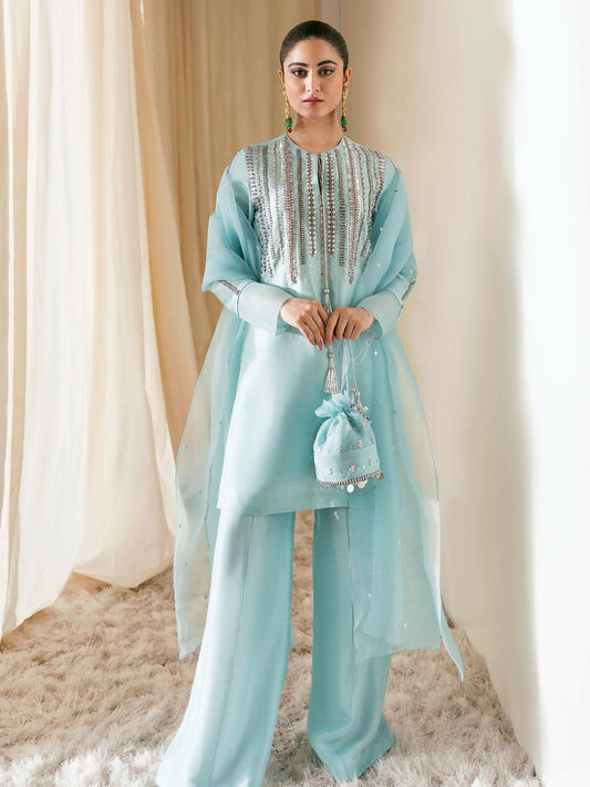 Hussain Rehar ice blue raw silk shirt with silver hand-embellished neckline, paired with raw silk palazzo pants and sprayed organza dupatta.